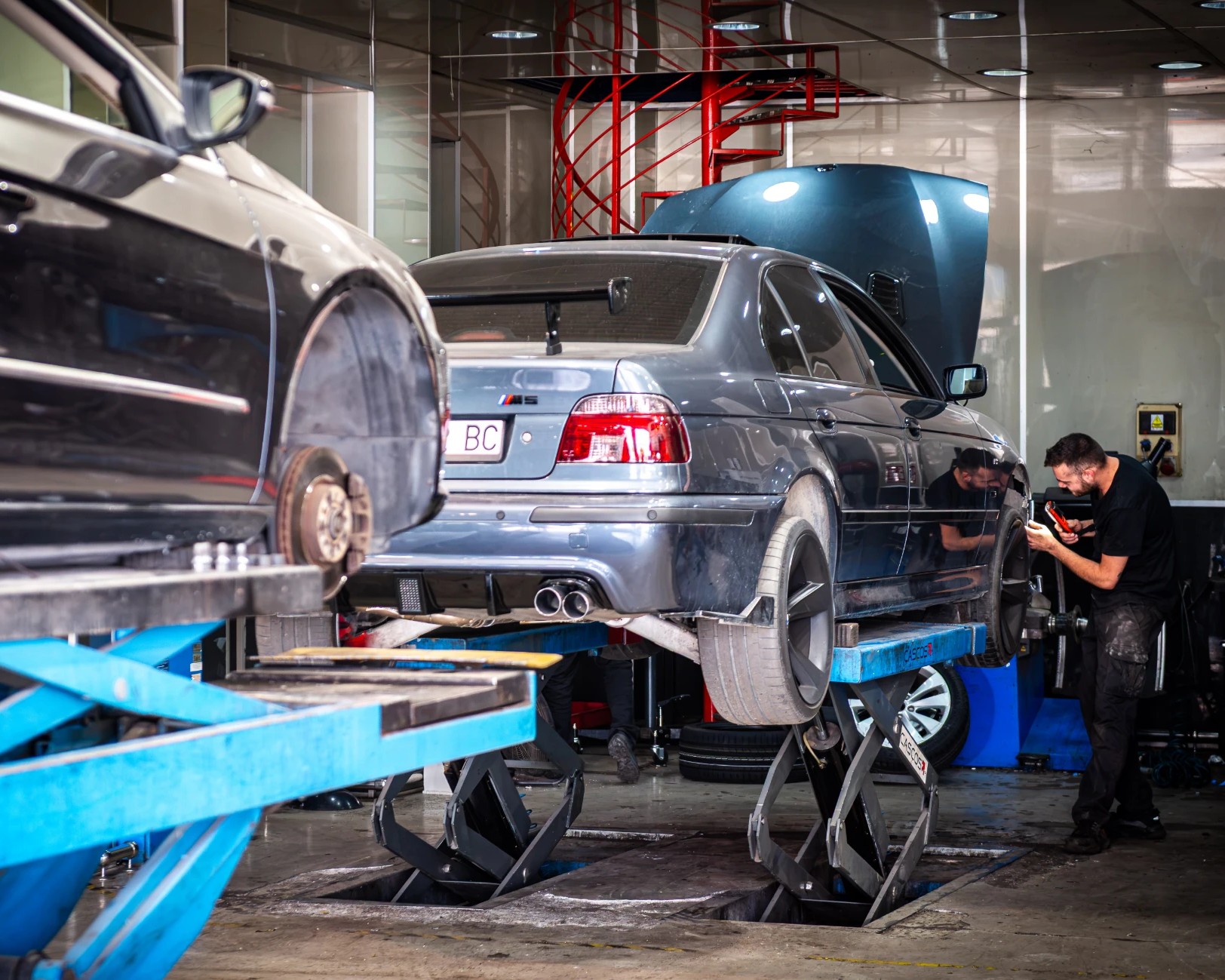 Mecánico revisando un BMW M5 elevado en el taller de Buitrago Centros