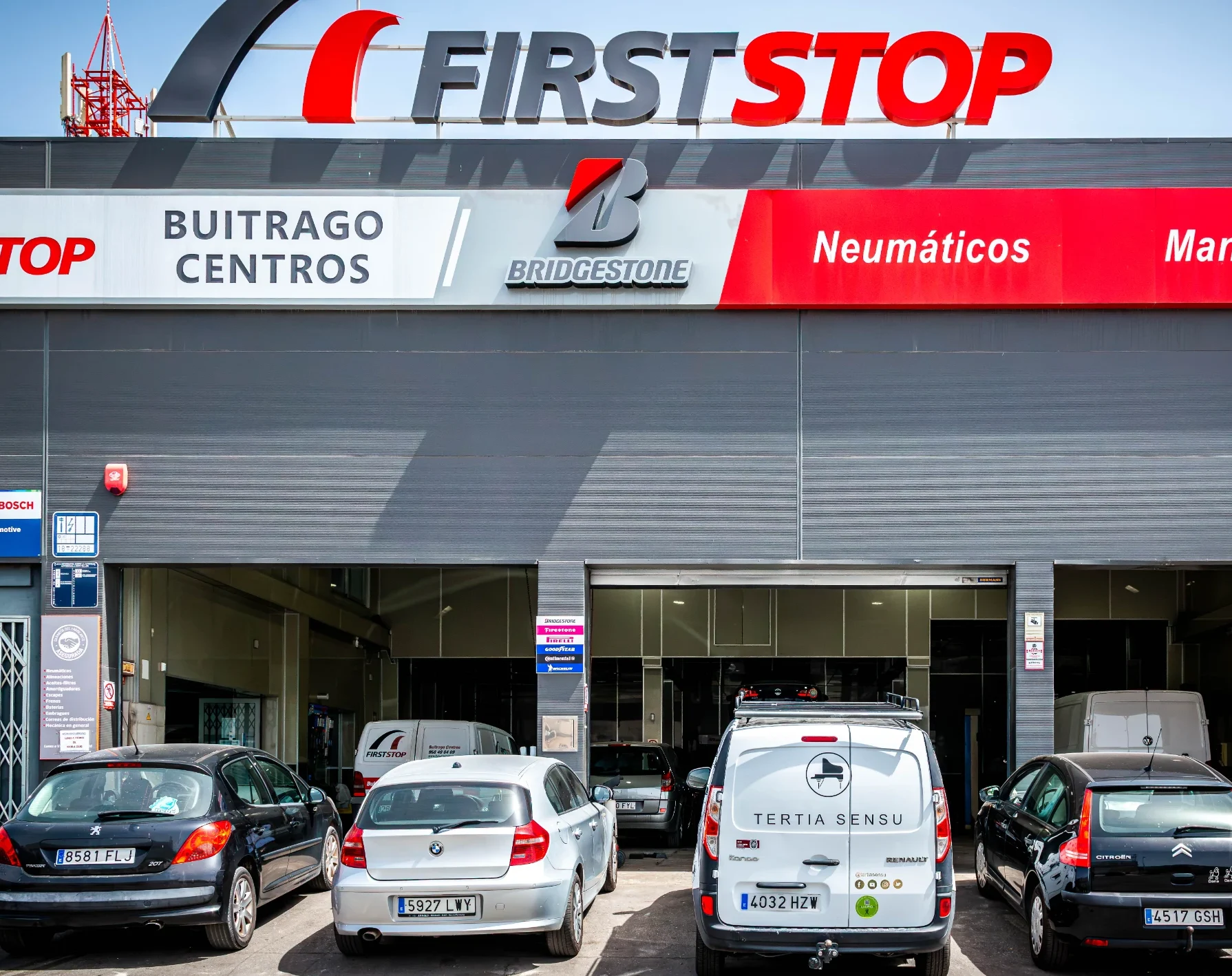 Fachada del taller First Stop Buitrago Centros con vehículos aparcados