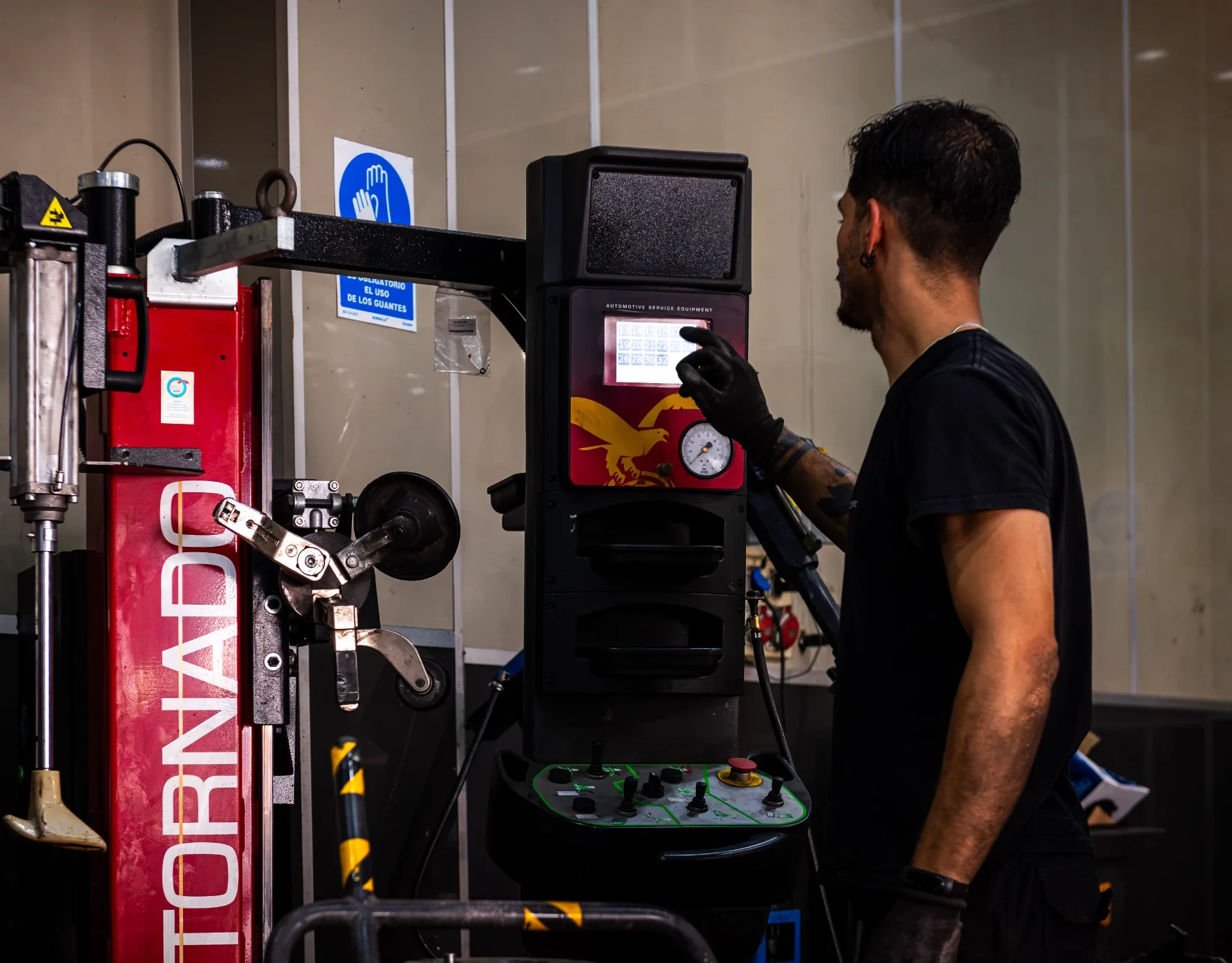 Mecánico consultando la pantalla de la máquina desmontadora Tornado