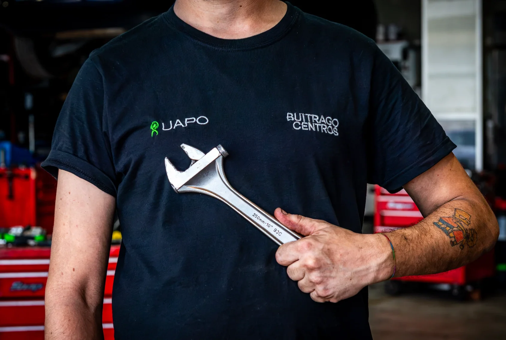 Mecánico de Buitrago Centros sujetando una llave inglesa en el taller